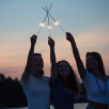 Girls playing with sparklers at sunset
